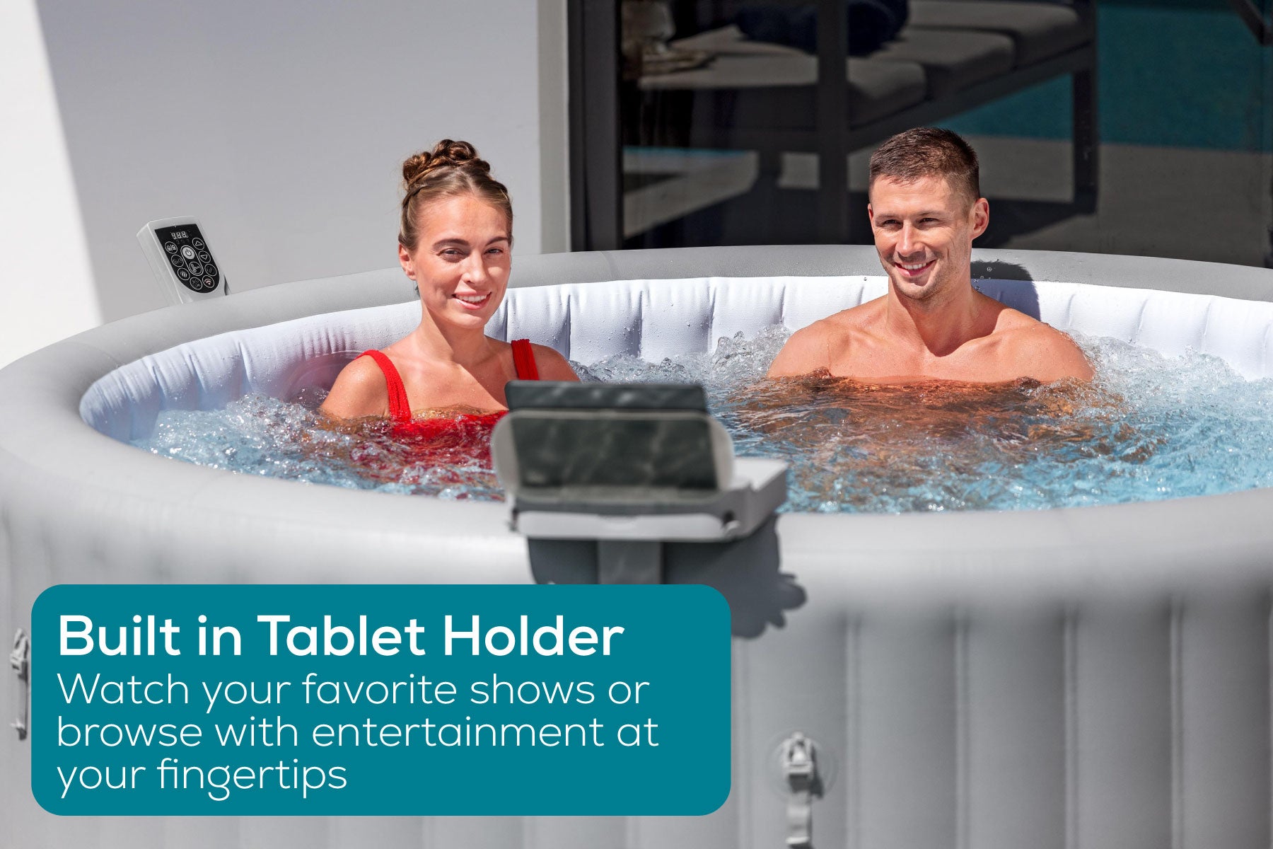 couple watching tv in their lay-z-spa on tablet up to an accessory tray