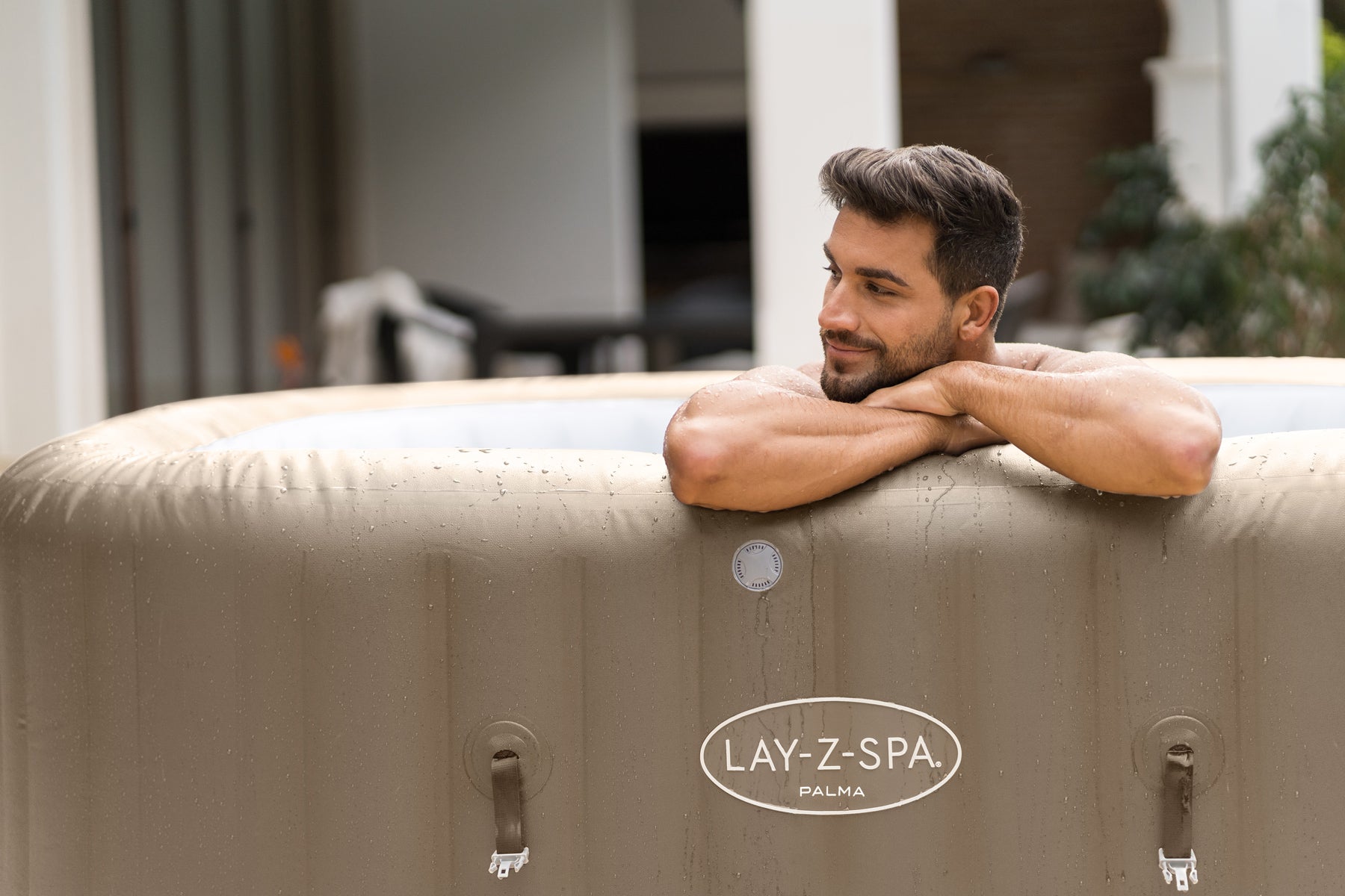 A man relaxes in the Lay-Z-Spa inflatable Palma Hydrojet Pro hot tub, surrounded by bubbles