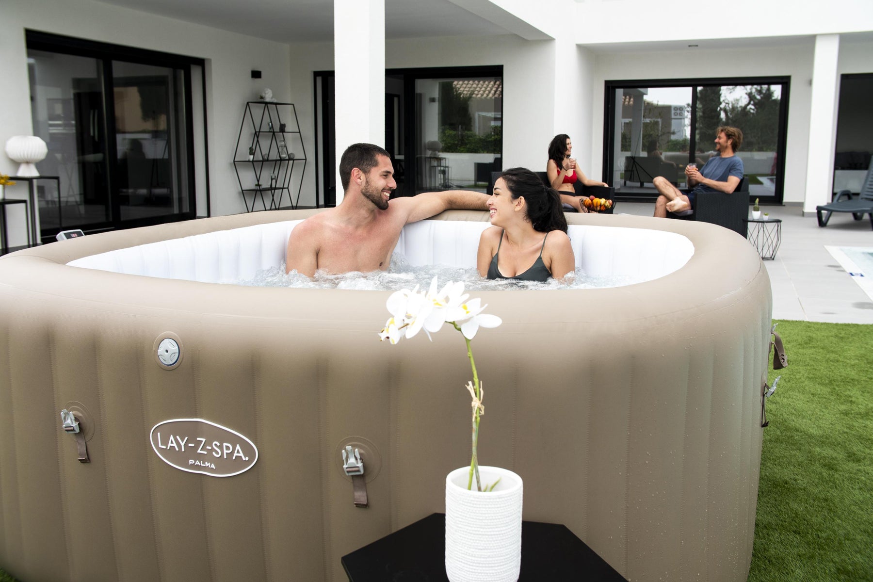 A couple enjoying a relaxing moment in a square inflatable Lay-Z-Spa Palma hot tub outdoors